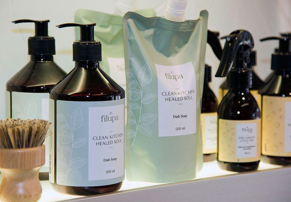 Flasker med hårplejeprodukter og shampoo på en hylde i en skønhedssalon.