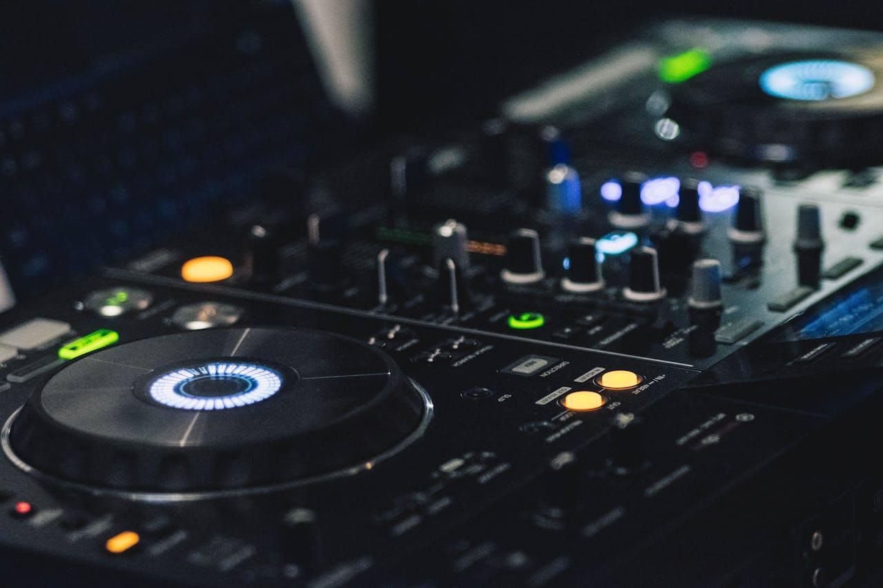 Et DJ-udstyr med pladespillere og kontrolknapper i et mørkt miljø.