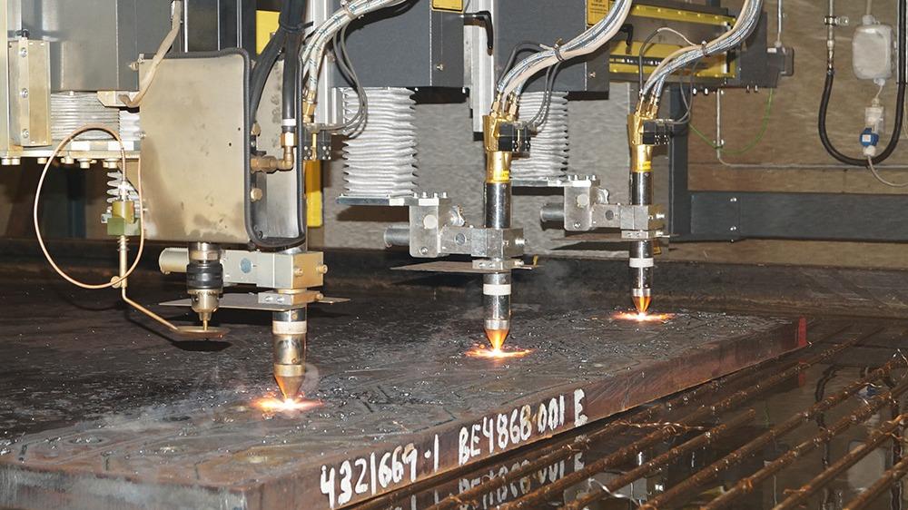 Industrielt skæreværktøj, der skærer metalplader med præcise brændere i en fabrik.